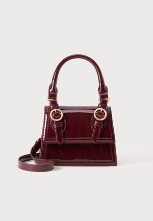 Burgundy patent leather handbag with dual top handles, gold hardware accents, and detachable shoulder strap. Rectangular shape with contrasting stitching.
