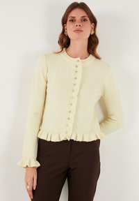 Lichtgele cardigan van zachte stof, met een ronde halslijn, een gerimpelde zoom en een knoopsluiting met decoratieve accenten.