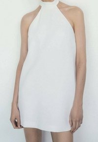 Robe blanche à dos nu avec un design ajusté et élégant. Texture lisse, style minimaliste, sans motifs visibles ni ornements.