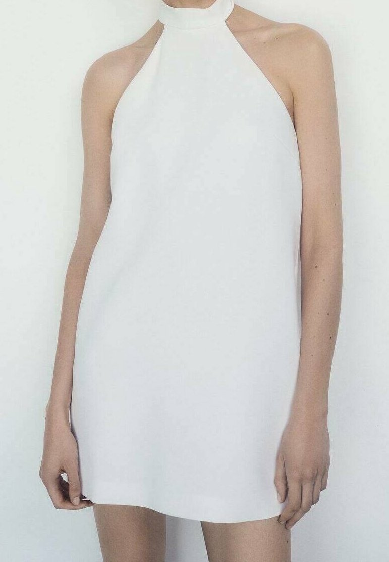 Robe blanche à dos nu avec un design ajusté et élégant. Texture lisse, style minimaliste, sans motifs visibles ni ornements.