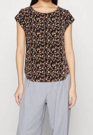 Haut à manches courtes avec un motif abstrait noir et marron. Tissu léger, coupe décontractée avec un col arrondi, associé à un pantalon gris clair.