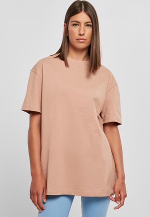 Lichtroze katoenen t-shirt met een relaxte pasvorm, korte mouwen, ronde halslijn en een gladde textuur. Gemaakt in combinatie met lichtblauwe broek.