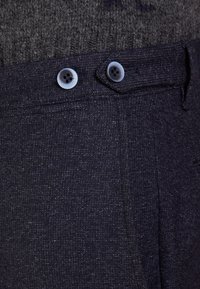 Námořnické kalhoty z texturované látky se dvěma modrými knoflíky v pase, s hladkým předním dílem a detailem boční kapsy.