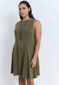 Rochie fără mâneci, de culoare verde măsliniu, cu un corset ajustat și fustă evazată. Include un pandantiv de aur cu un design rotund. Material fin, ușor.