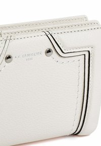 Cartera de cuero blanco con superficie texturizada, costuras negras contrastantes, acentos plateados y logotipo de la marca en relieve con el año.