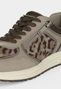 Baskets beiges avec lacets marron foncé, panneaux imprimés léopard, fermeture éclair latérale et semelle blanche rembourrée.