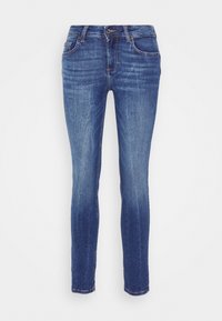 Vaqueros ajustados de denim azul con un lavado desgastado, diseño de cinco bolsillos y un pequeño logotipo bordado en la parte trasera. Costuras en color contrastante.