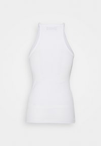 Valkoinen hihaton ribbattu toppi korkealla kauluksella ja tiukalla vyötäröllä, kuvattuna takaa yksinkertaista valkoista taustaa vasten.