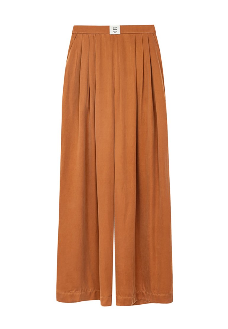 Spodnie typu wide-leg w kolorze rdzy. Posiadają plisowany fason, elastyczny pas oraz gładką strukturę. Brak dodatkowych wzorów i elementów ozdobnych.