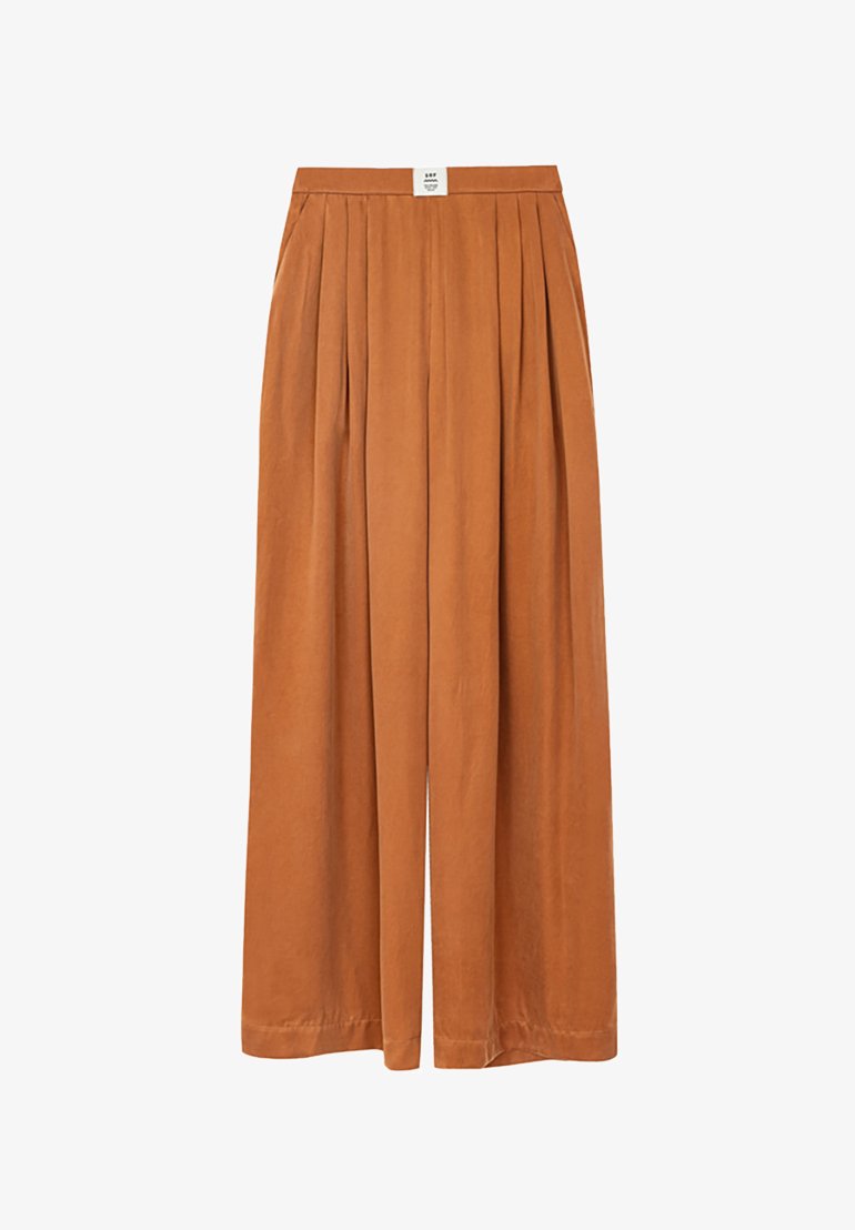 Spodnie typu wide-leg w kolorze rdzy. Posiadają plisowany fason, elastyczny pas oraz gładką strukturę. Brak dodatkowych wzorów i elementów ozdobnych.