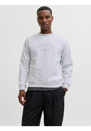 Svetlo sivi pulover s kapuco, ki ima rebraste manšete in spodnji del, z izvezenim besedilom "ORIGINALS" v subtilni, usklajeni niti na sprednji strani.