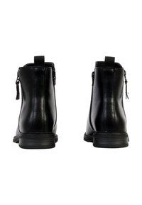 Paire de bottines en cuir noir avec languettes de tirage à l'arrière et fermetures éclair latérales, vue de dos sur fond blanc.