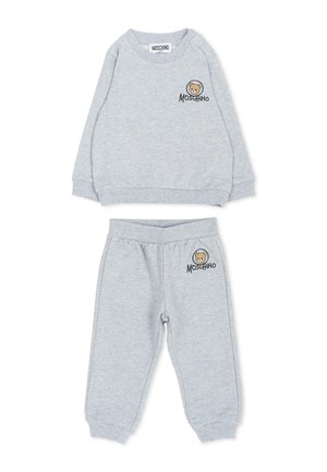 Jasnoszary dziecięcy komplet bluzy i spodni z twarzą niedźwiedzia i logo "Moschino" w lewym górnym rogu bluzy i spodni.