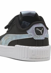 Crna sintetička tenisica s iridescentnim Puma prugom, bijelim potplatom i teksturiranim petnim dijelom. Sadrži oznaku s logotipom i remen s čičak sustavom.