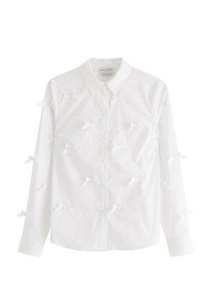 Vit skjorta med knapp-up, tillverkad av bomull, med långa ärmar. Den har små vita rosett detaljer som är jämnt fördelade över framsidan och ärmarna.