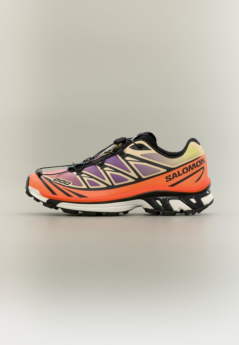Chaussure de trail running aux couleurs noir, orange, violet et beige, avec un système de laçage rapide et la marque "Salomon" sur le côté.
