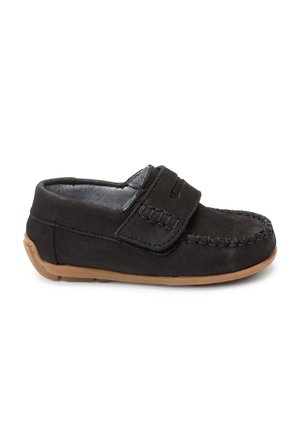 Mocassin enfant en daim noir avec sangle velcro et semelle en caoutchouc marron, vu de profil sur fond blanc.