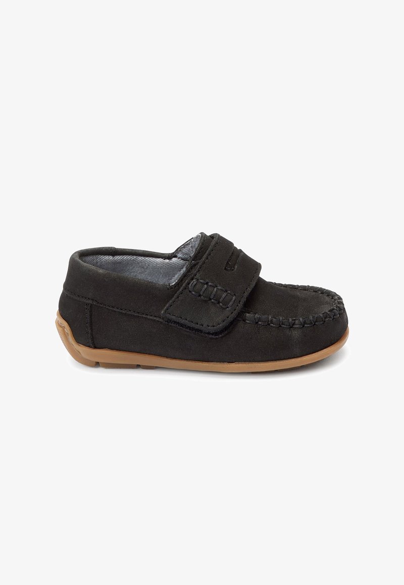 Mocassin enfant en daim noir avec sangle velcro et semelle en caoutchouc marron, vu de profil sur fond blanc.
