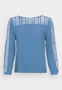 Top azul de manga longa com um tecido suave, apresentando detalhes em renda nas mangas e ombros, e um decote arredondado.