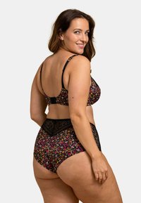 Ensemble de lingerie floral noir comprenant un bralette et une culotte taille haute. Motif floral en rose, jaune et blanc avec des détails en dentelle.