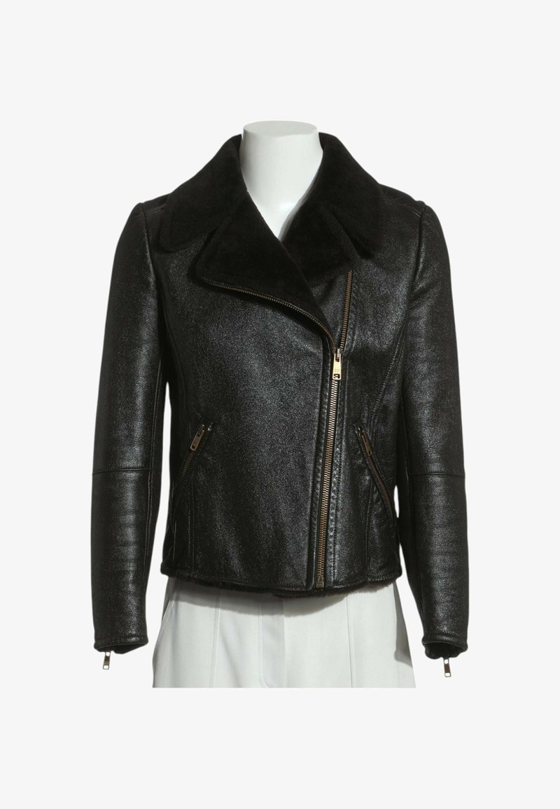 Veste en cuir noire avec fermeture éclair asymétrique à l'avant, grand col, poches latérales zippées et poignets zippés, exposée sur un buste de mannequin blanc.