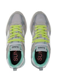 Scarpe da ginnastica grigio e bianche realizzate in materiali mesh e sintetici, con lacci verde brillante, colletto imbottito e logo all'interno nero.
