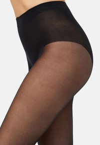Tights semitranslúcidos negros con una textura suave. La cinturilla es gruesa y elástica, y el material parece transparente en las piernas.