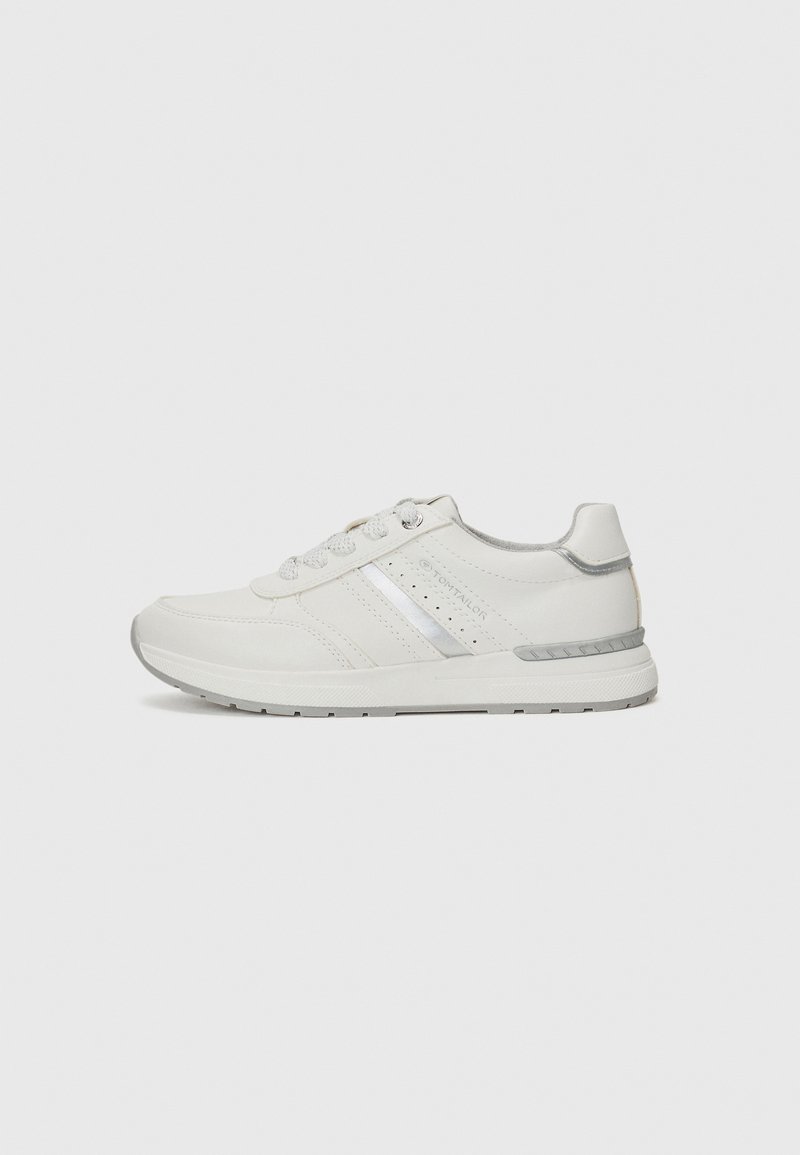 Hvit sneakers med en glatt skinnoverdel, sølvstripe-detaljer, perforerte detaljer og en grå gummisåle med mønster.