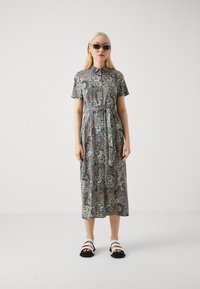 Paisley-patterned dress in lightweight fabric, short sleeves, and a collared neckline. Features a tied waist detail and a midi length.