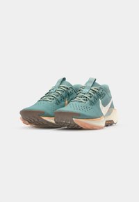 Turquoise running shoes with a breathable upper, white swoosh logo, textured sole, and orange accents on the outsole.