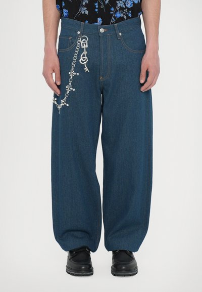 Dark blue wide-leg denim jeans with decorative chain featuring charms. Five-pocket design, visible stitching and belt loops.
