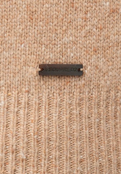 Beiger Strickpullover mit strukturiertem Muster; verfügt über ein rechteckiges schwarzes Stoffetikett mit eingeprägtem "DSQUARED2" in der Mitte.