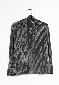 Pull-over scintillant noir et gris avec capuche, présentant un mélange de motifs d'imprimés animaliers et une fermeture éclair avant à mi-hauteur. Texture de tissu doux.