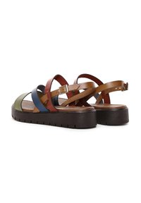 Sandalias de cuero multicolor con una suela gruesa marrón, tiras cruzadas en verde, azul, rojo y marrón, con una planta texturizada y hebilla ajustable.