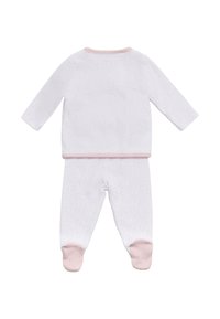 Pijamas de bebé blancos con mangas largas y pantalones con pies, que presentan lunares rosas claros y ribetes rosas en el cuello, los puños y los pies.