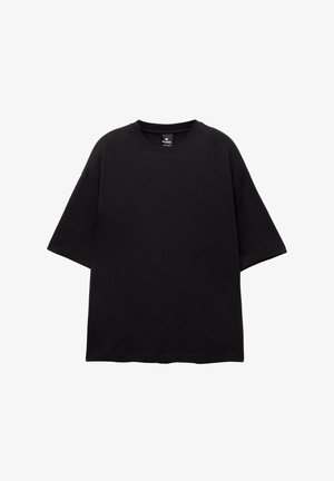 Black oversized t-shirt made of cotton. Short sleeves, round neck, and a straight hem. No patterns or embellishments. Simple and modern design.