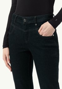 Donkerdenim jeans met een getailleerd ontwerp, vijf zakken, zichtbare stiksels en een metalen knoopsluiting aan de voorkant.