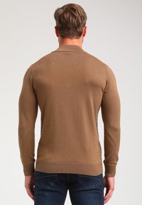 Brauner, gestrickter Pullover mit geripptem Saum und Bündchen, taillierter Passform und langen Ärmeln. Die Rückansicht zeigt eine glatte Textur ohne Muster.