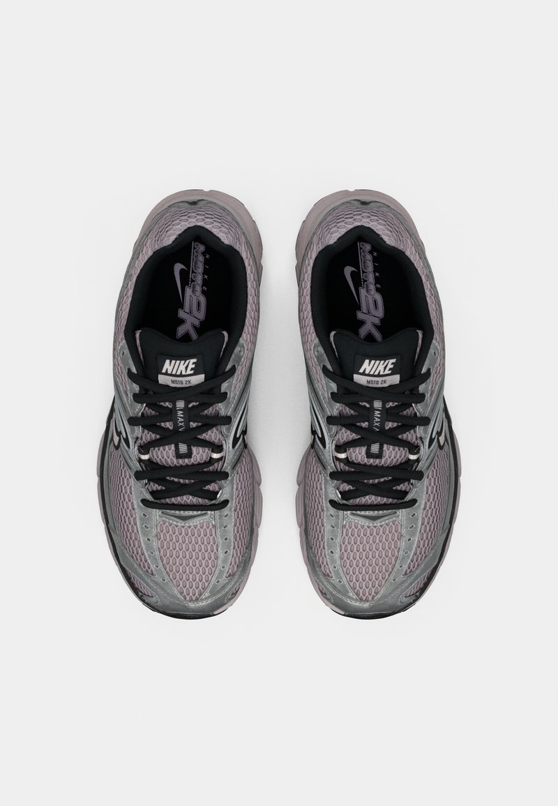 Zapatillas Nike Air Max en gris y negro, con una parte superior de malla, cordones negros planos, cuello acolchado y suela de goma texturizada.