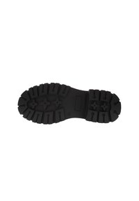 Suela de bota de goma negra con profundos surcos, múltiples patrones de tracción y una sección lisa cerca del talón. Hendidura rectangular cerca del centro.