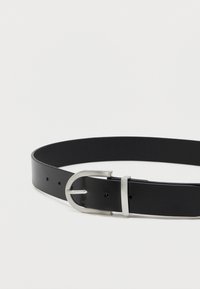 Czarny skórzany pasek o gładkim wykończeniu, z posrebrzaną metalową klamrą i wieloma otworami do regulacji wzdłuż paska.