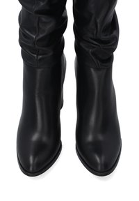Schwarze Lederstiefeletten mit einem eleganten, anliegenden Design, spitzem Zehenbereich und strukturiertem Obermaterial. Glatte Oberfläche und moderater Absatz.