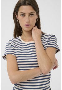 Camiseta a rayas con rayas horizontales en navy y crema, un escote redondo y mangas cortas, hecha de una tela acanalada.