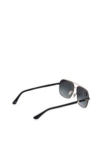 Lunettes de soleil en métal noir et or avec verres carrés foncés et branches fines noires présentées sur fond blanc.