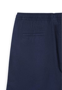 Pantaloni blu navy con una cintura elastica e una sola tasca a soffietto orizzontale sul retro.
