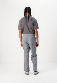 Gray t-shirt and matching gray pants with an elastic waistband, displayed from the back. The fabric appears soft with a smooth texture.