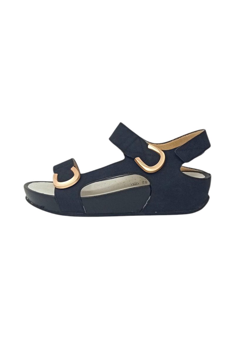 Sandal navy blu con una texture in camoscio, doppie cinghie regolabili e accenti in metallo circolare color oro. Sole leggermente elevato per il comfort.