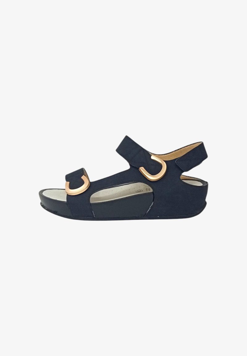 Sandal navy blu con una texture in camoscio, doppie cinghie regolabili e accenti in metallo circolare color oro. Sole leggermente elevato per il comfort.