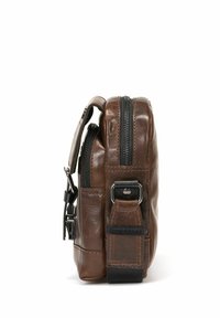 Brązowa skórzana kompaktowa torba z górnym zamkiem błyskawicznym, boczną rączką i regulowanym paskiem. Posiada teksturowane akcenty i wzmocnione szwy.