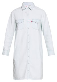 Light blue denim shirt dress with long sleeves, button-up front, two chest pockets, and a pointed collar. Textured fabric, casual design.